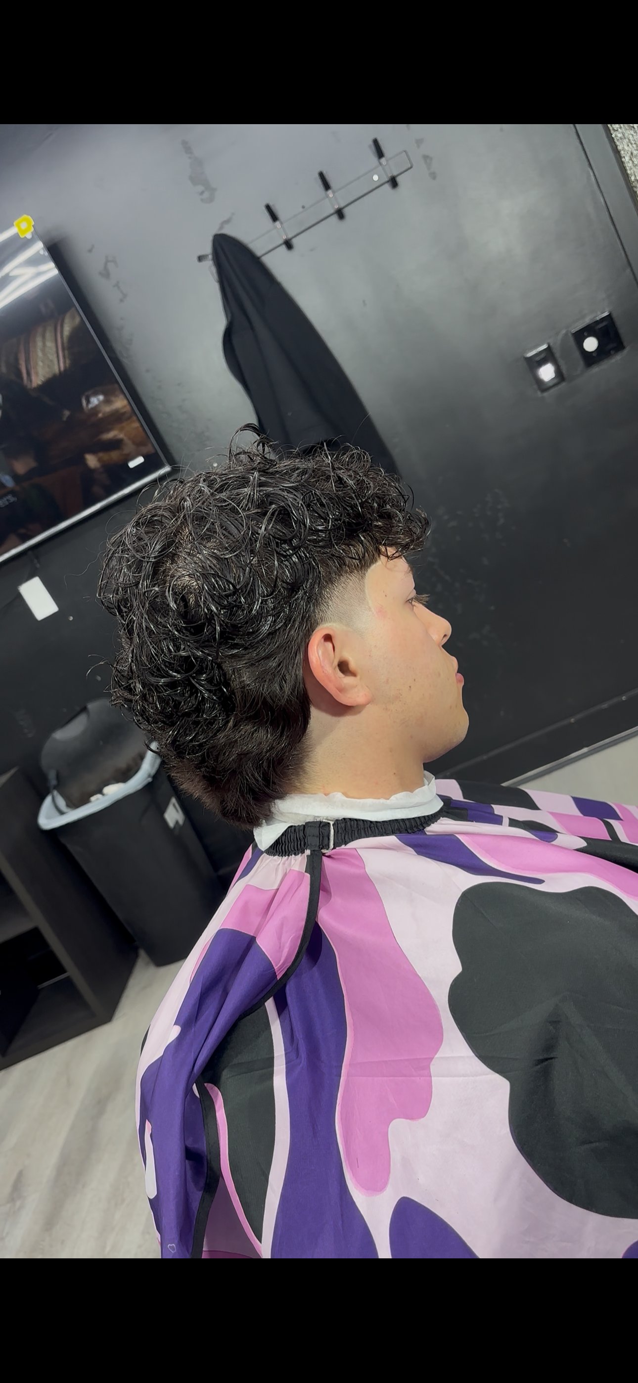 Curly taper fade haircut, side profile